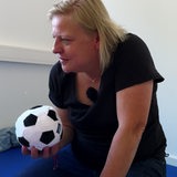 Eine Frau hält einen Ball in der Hand.