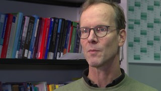 Der Bremer Epidemiologe Hajo Zeeb im Interview vor einem Bücherregal.