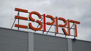 Das Logo der Modekette Esprit ist auf einem Gebäude befestigt.