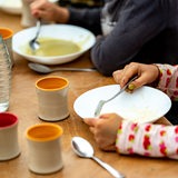 Die Kinder einer Kita essen ihr Mittagessen.