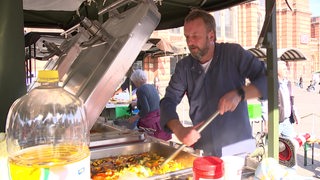 Ein Koch am kochen vorm Bahnhof open air.