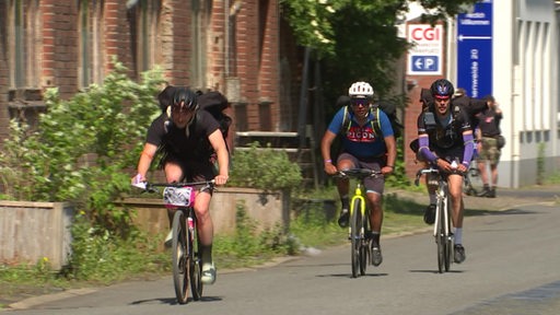 Drei Fahrradkuriere liefern sich ein Rennen