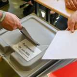 Ein Mann wirft seine Stimme während der Europawahl in eine Wahlbox.
