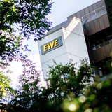 Das Logo des Unternehmens "EWE" hängt an der Hauptverwaltung des Energieversorgers. 