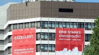 Zwei rot-weiße Transparente zur Exzellenzinitiative hängen am 18.06.2012 an der Fassade des Mehrzweckhauses der Universität Bremen. 