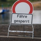 Ein Schild mit der Aufschrift "Fähre gesperrt" steht am Wasser.