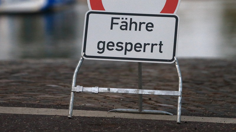 Ein Schild mit der Aufschrift "Fähre gesperrt" steht am Wasser.