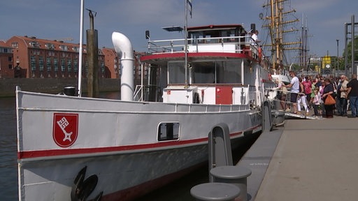 Auf ein Rundfahrtenschiff, welches an der Weserpromenade liegt, gehen Passergiere an Bord.