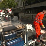 Ein Bauarbeiter markiert einen neuen Radweg auf der Martinistraße in Bremen.