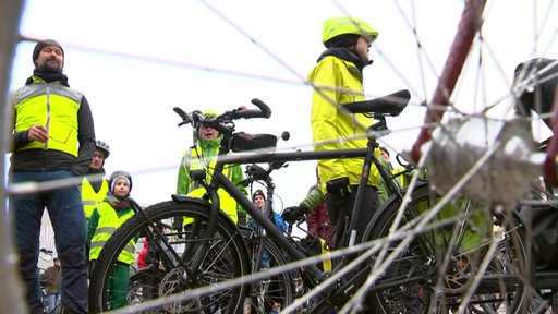 Eine Versammlung von mehreren Menschen mit Fahrrädern.