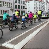 Es sind mehrere Kinder und ein paar Erwachsene auf Fahrrädern zu sehen.