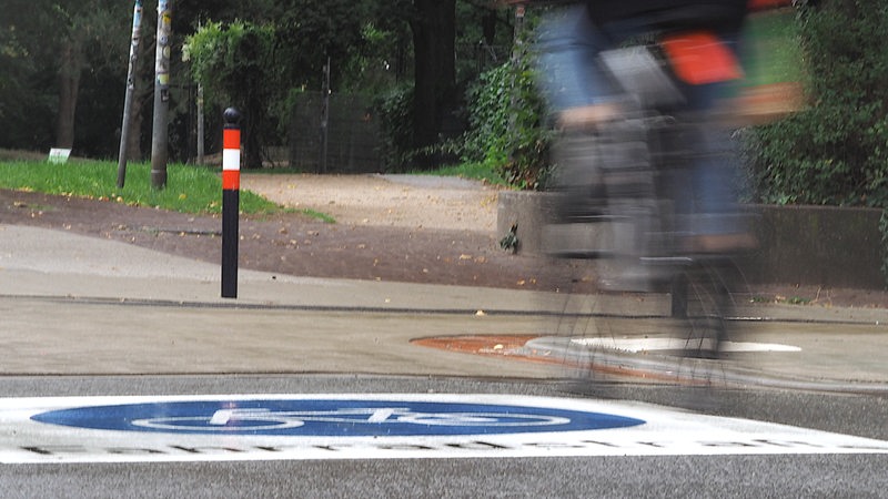 Eine Fahrradfahrerin fährt über ein aufgemaltes Fahrradstraßen Piktogram in der Bremer Neustadt.