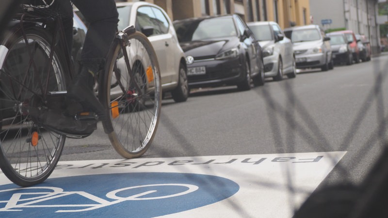 Eine Radfahrerin fährt über ein falsch aufgetragenes Fahrradstraßen-Piktorgram im Fahrradmodellquartier.
