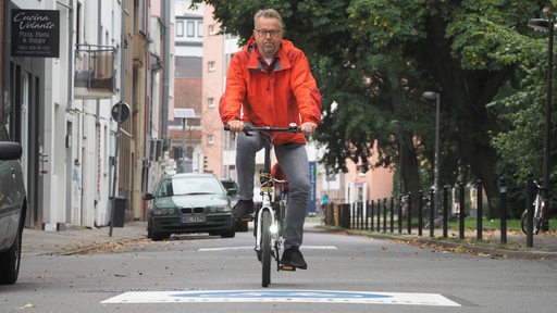 Michael Glotz-Richter fährt mit seinem Fahrrad durch eine Bremer Fahrradstraße.
