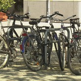 Es sind mehrere Fahrräder an Fahrradständern angeschlossen. 