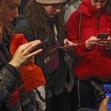 Eine Gruppe von jungen Frauen schaut auf ihre Smartphones