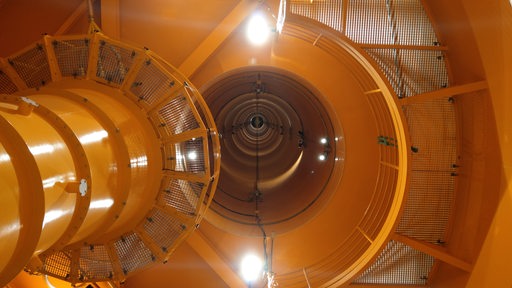 120 Meter geht der Blick in die orange-gelbe Röhre des Fallturms hinauf.
