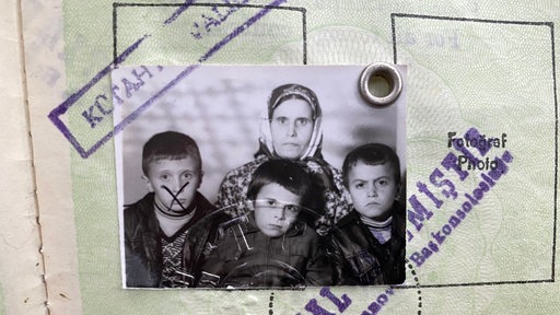 Detailaufnahme eines türkischen Passes mit einem Familienfoto, Mutter mit drei Söhnen