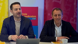 Thore Schäck und Hauke Hilz sitzen nebeneinander