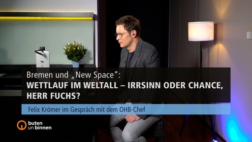 Ein Mann, Felix Krömer, sitzt an einem Tresen mit dem Schriftzug Bremen und New Space: Wettlauf im Weltall – Irrsinn oder Chance, Herr Fuchs?