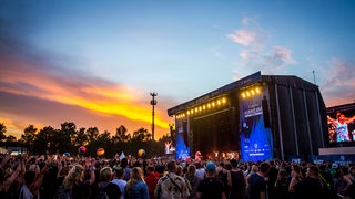 Menschen vor einer Festival-Bühne