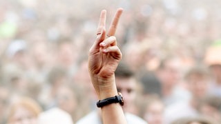 Eine Festivalbesucherin streckt auf dem Hurricane Festival ihre Hand in die Höhe