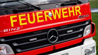 Ein Einsatzfahrzeug der Feuerwehr steht im Rahmen einer Übung auf einem Parkplatz.