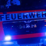 Ein Feuerwehrauto ist mit Blaulicht auf dem Weg zum Einsatz.