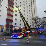 Ein Feuerwehrwagen steht vor einem Hochhaus.