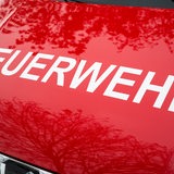Die Motorhaube mit der Aufschrift "Feuerwehr" eines Einsatzwagens der Feuerwehr 