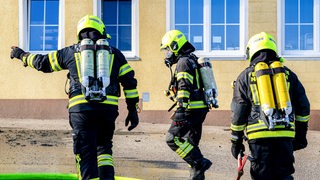 Drei Feuerwehrleute mit Atemschutzgeräten