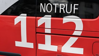 Auf einem Feuerwehrwagen steht die Aufschrift "Notruf 112".
