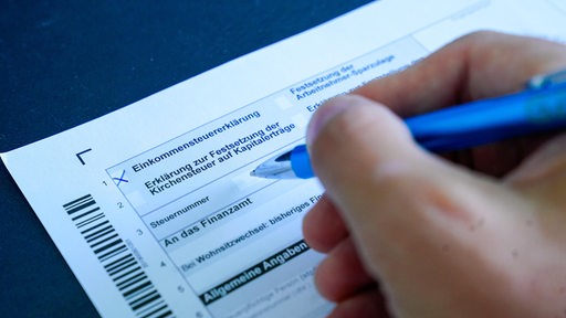 Ein Mitarbeiter eines Finanzamts nimmt Formulare zur Steuererklärung aus einem Regal. (Symbolbild)