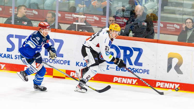 Pinguins-Angreifer Jake Virtanen sprintet seinem Gegenspieler übers Eis davon.