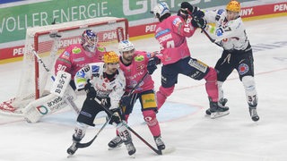 Mehrere Spieler der Fischtown Pinguins und Eisbären Berlin liefern sich Rangeleien vor dem Eisbären-Tor.