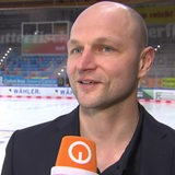 Pinguins-Manager Sebastian Furchner lächelt während eines Interviews.