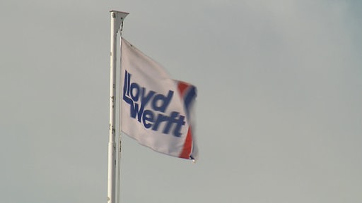 Eine Flagge mit der Aufschrift "Lloyd Werft" weht im Wind.
