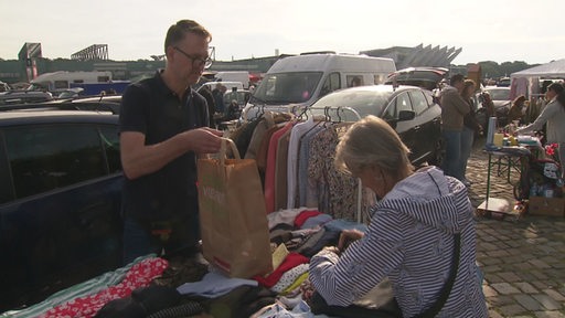 Einer Frau hat etwas beim Flohmarkt gekauft. 