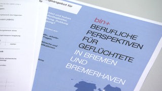 Auf einem Prospekt steht "Berufliche Perspektiven für Geflüchete in Bremen und Bremerhaven".