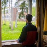 Ein junger syrischer Flüchtling blickt aus dem Fenster seiner Unterkunft.