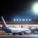 Ein Flugzeug steht nachts auf dem Rollfeld vom Flughafen Bremen.