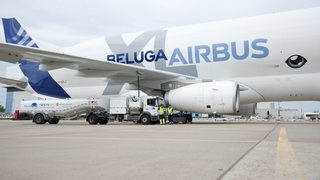 Flugzeug Beluga Aribus wird betankt, davor zwei Männer