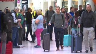 Viele Reisende mit Koffern stehen am Bremer Flughafen.