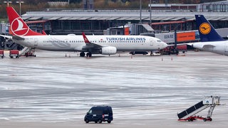 Ein Flugzeig und ein Polizeiauto stehen auf dem Vorfeld des Hamburger Flughafens