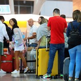 Reisende warten am Flughafen mit ihren Koffern auf ihren Flug