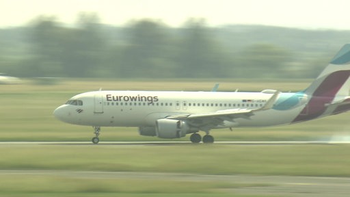 Ein Flieger des Konzerns Eurowings landet auf einer Landebahn.