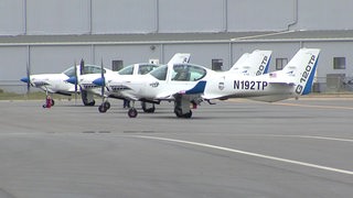Vier Flugzeuge, die geparkt auf einer Rollbahn stehen.