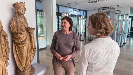 Zwei Frauen betrachten historische Skulpturen im Focke-Museum in Bremen