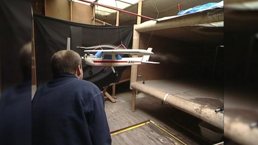 Eine Archivaufnahme aus dem Focke Windkanal, auf der die Luftströmung um ein Miniaturflugzeug untersucht wird. 