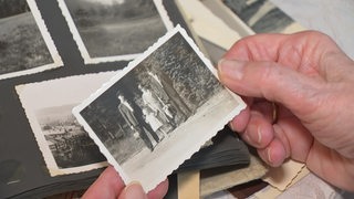 Ein altes schwarz-weiß Bild einer Familie wir aus einem Fotoalbum genommen.